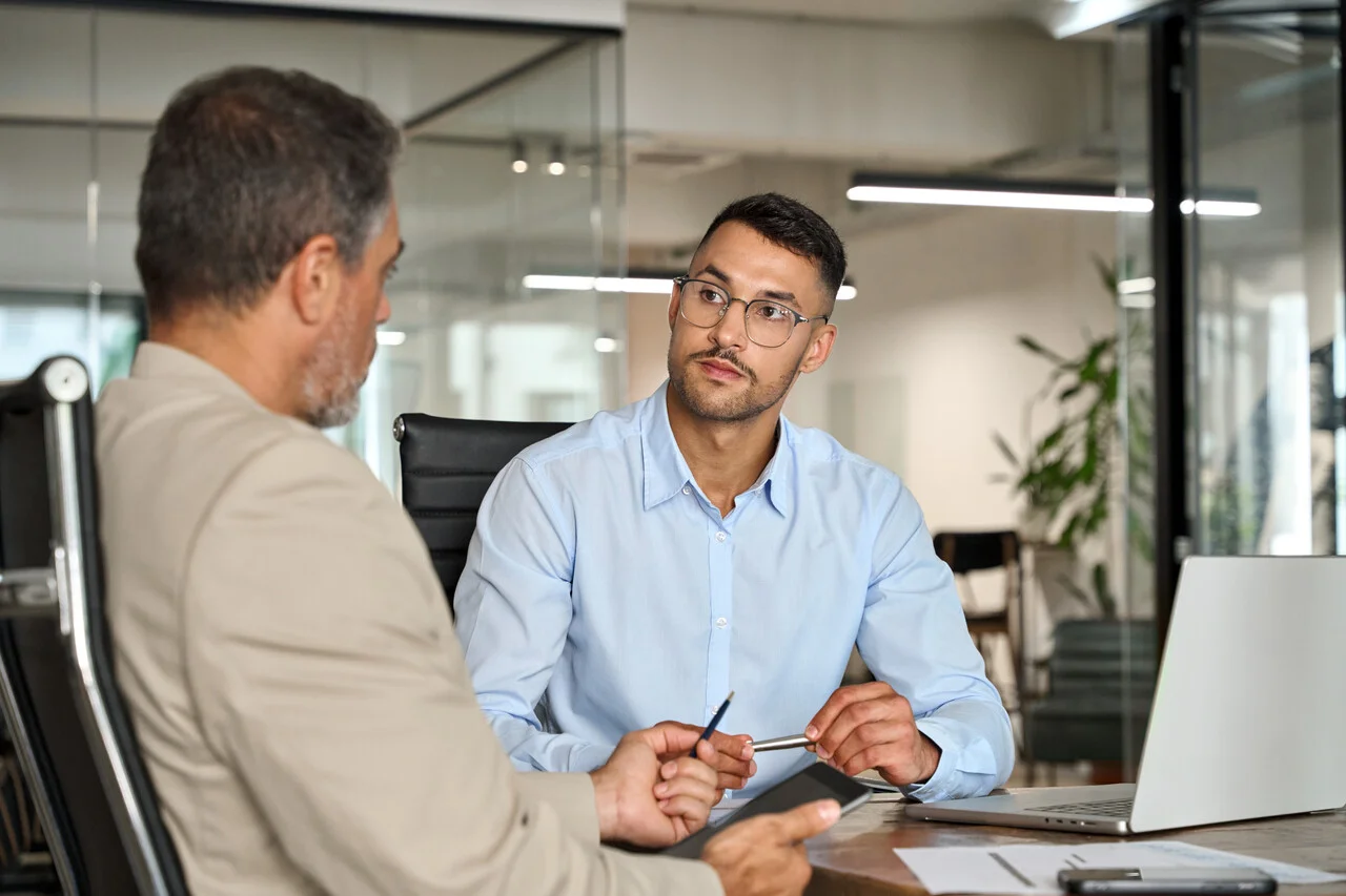 Busy executive team of two business men working in office with laptop computer.